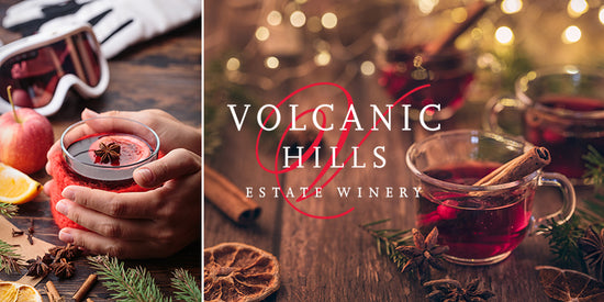 ingredients to make Volcanic Hills mulled wine are laid out on a white wooden christmas and holiday themed table.  Ingredients include star anise, cloves, a wooden spoon, wine, dried oranges, brown sugar and a festive candy cane and fir branch
